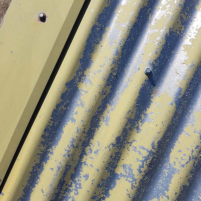 A close up of a roof with severe flaking paint